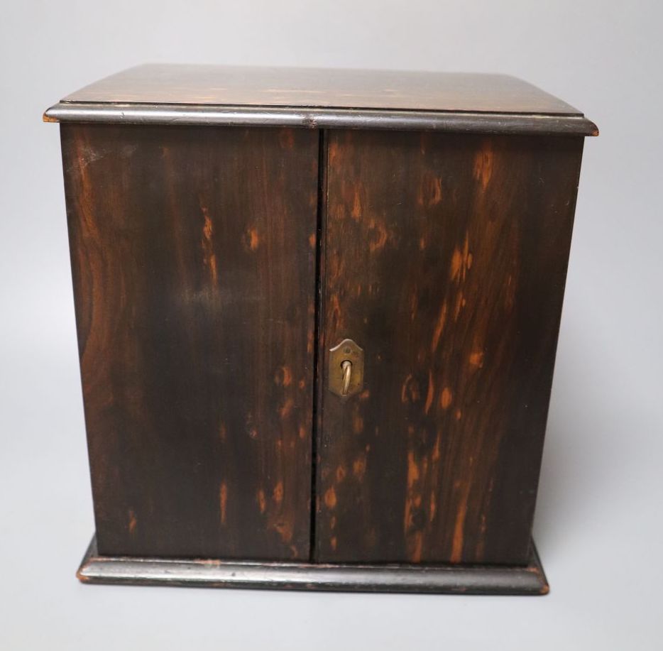 A Victorian coromandel cabinet with three drawers and two doors, with key, 22cm wide